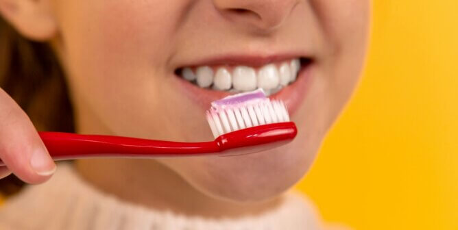 A person bringing a toothbrush to their teeth